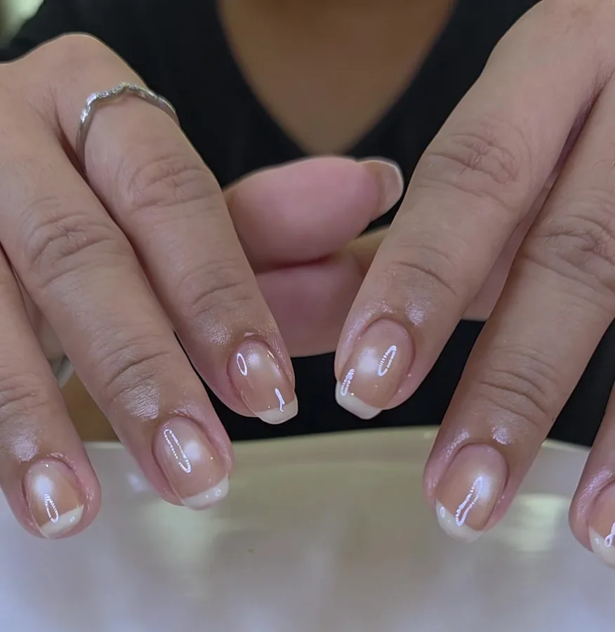 Natural nails in a sheer nude gel with a white French tip, glossy finish, Nanny Nails Nakhon Phanom