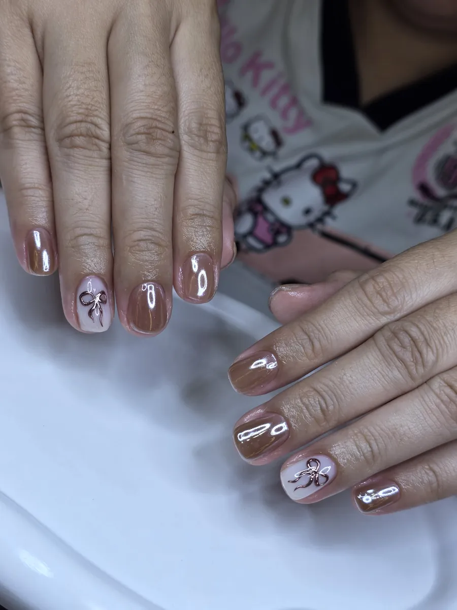 Mocha chrome gel nails with fine painted bows, Nanny Nails, nail salon in Nakhon Phanom