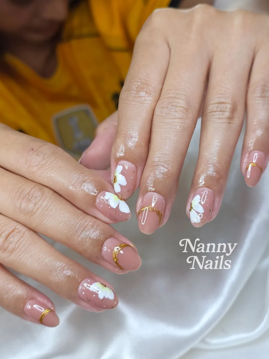 Nude gel nails with painted white flowers and thin gold lines, Nanny Nails, nail salon in Nakhon Phanom