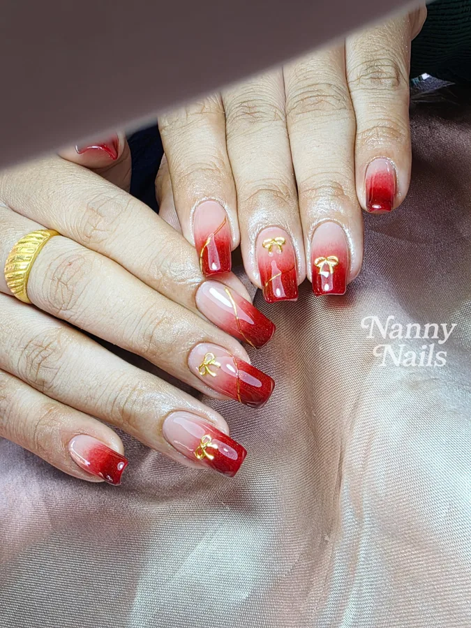 Red ombre nails with gold lines and gold bows, Nanny Nails, nail salon in Nakhon Phanom