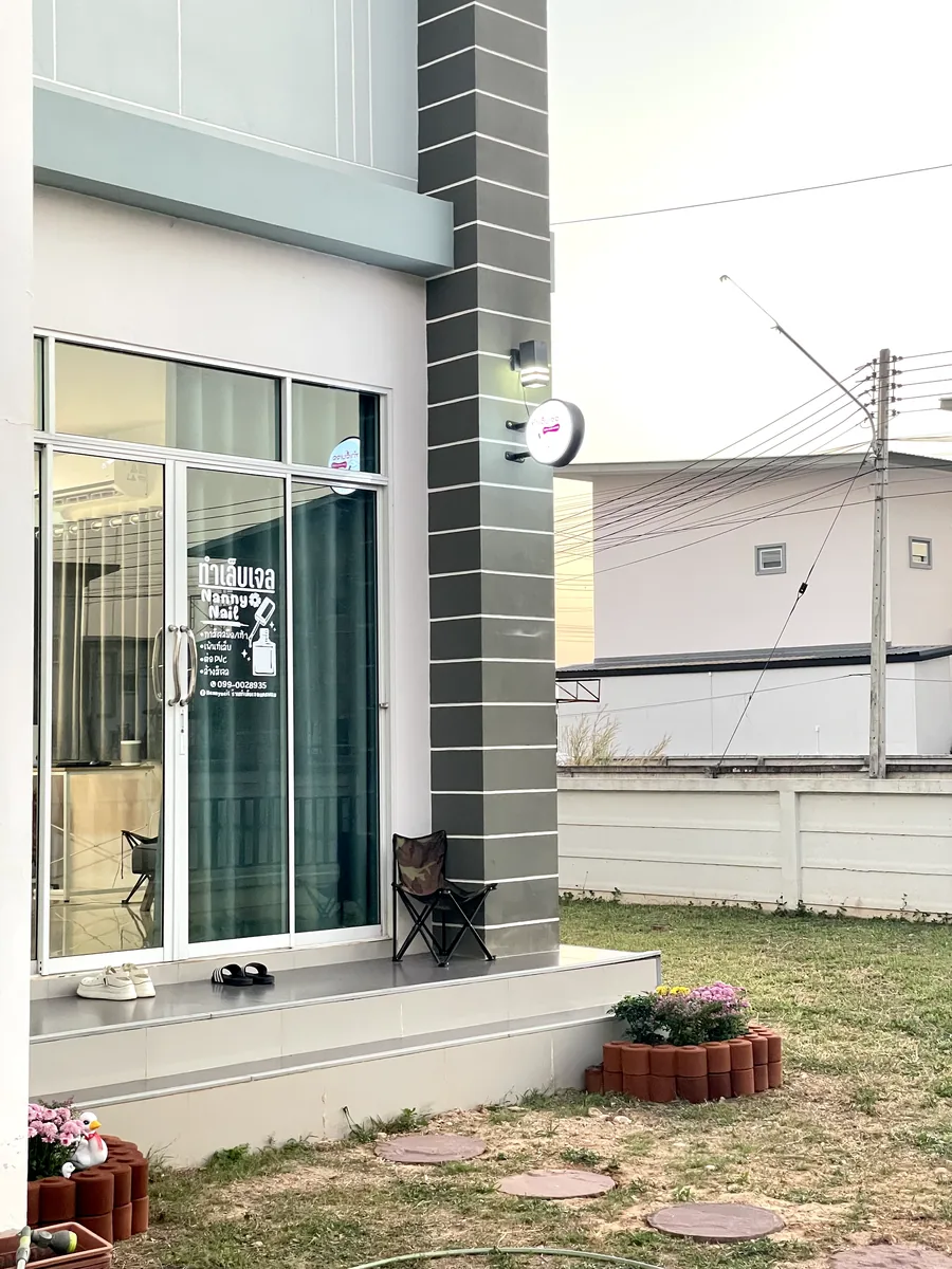หน้าร้านทำเล็บในบ้าน ประตูกระจกติดชื่อร้านและป้ายไฟกลม สังเกตได้ตอนลงรถ ร้านทำเล็บนครพนม Nanny Nails