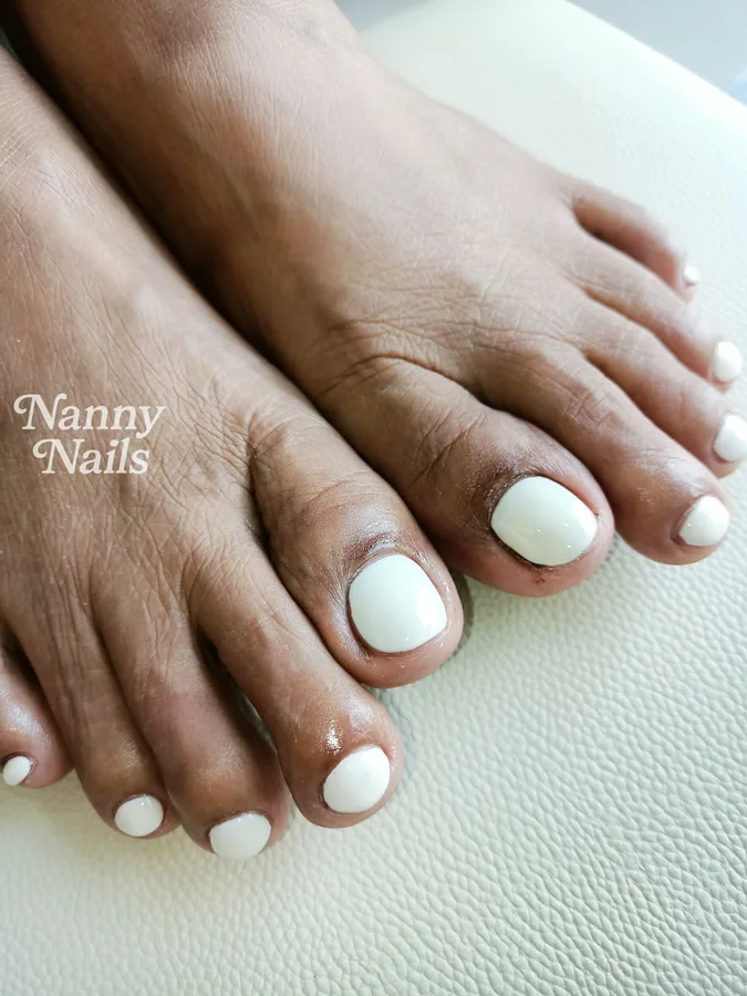 เล็บเท้าเจลสีขาวคลีน ตัดกับผิวเท้าโทนเข้ม ร้านทำเล็บนครพนม Nanny Nails